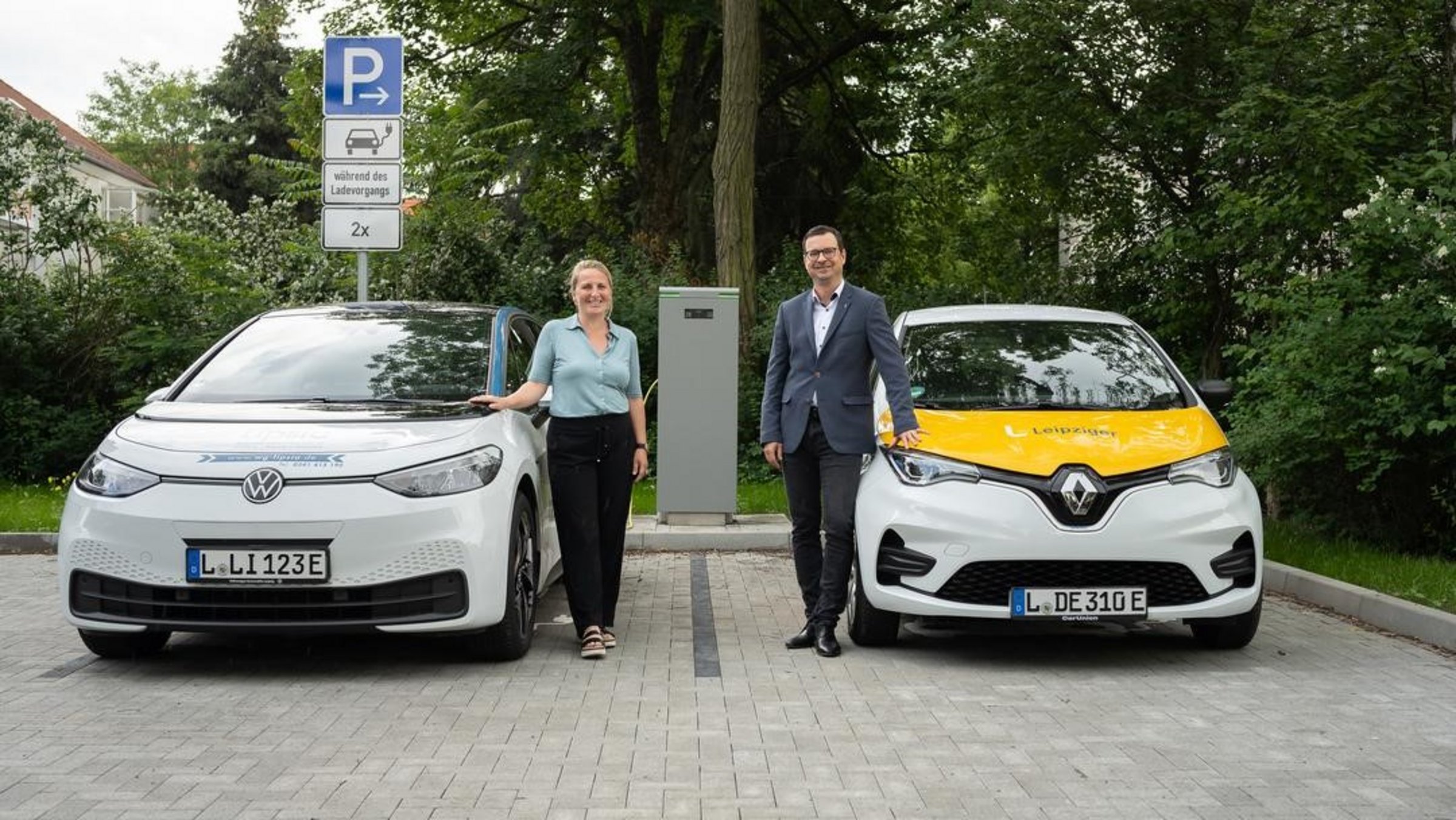 Zwei Autofahrer laden ihre E-Autos auf.