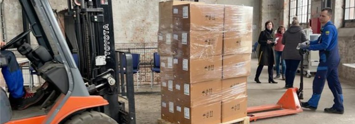 Ein Gabelstapler nimmt Paletten mit Hilfsgütern auf.