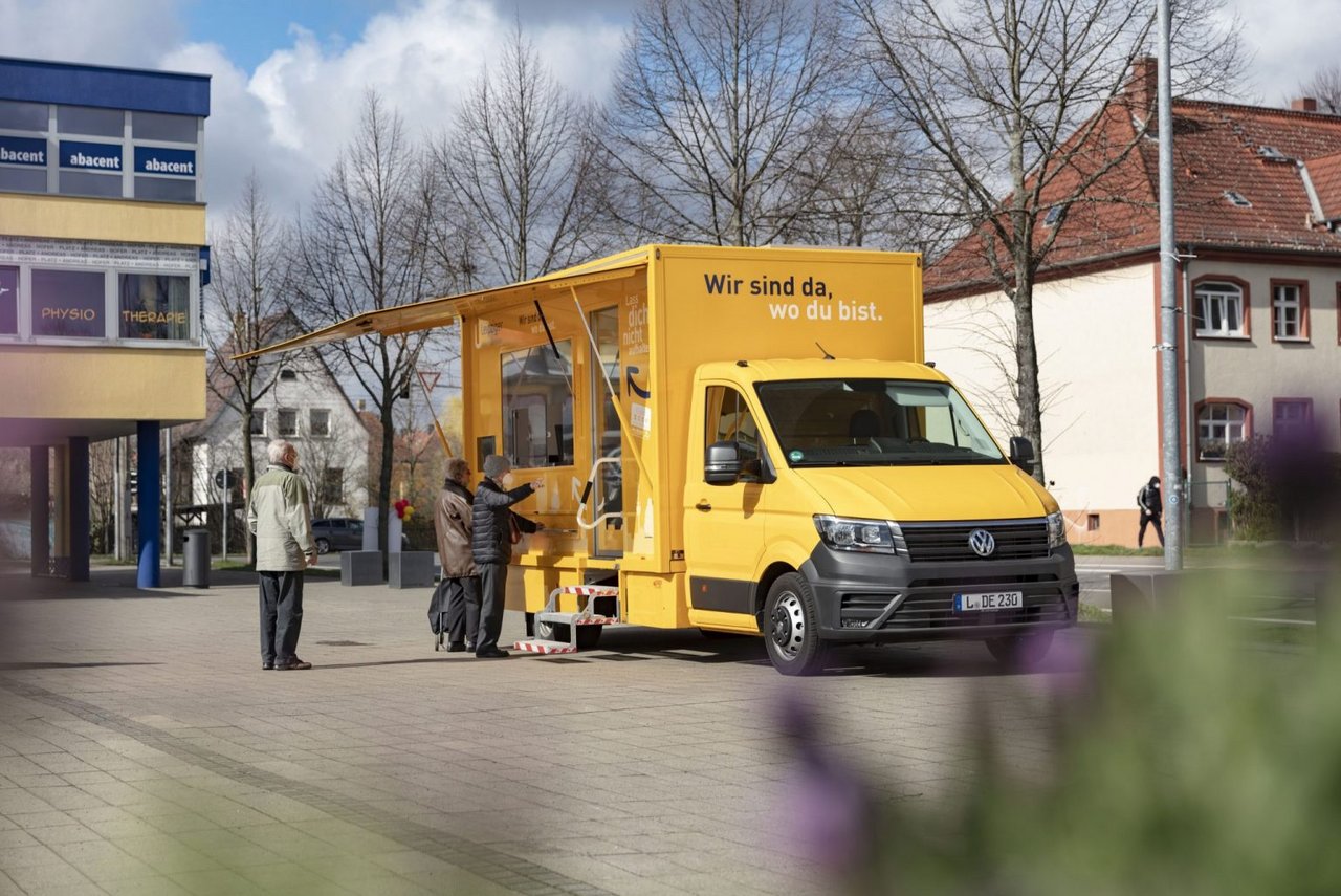 Das Servicemobil aus der Ferne. Einige Kunden stehen in einer Schlange an.