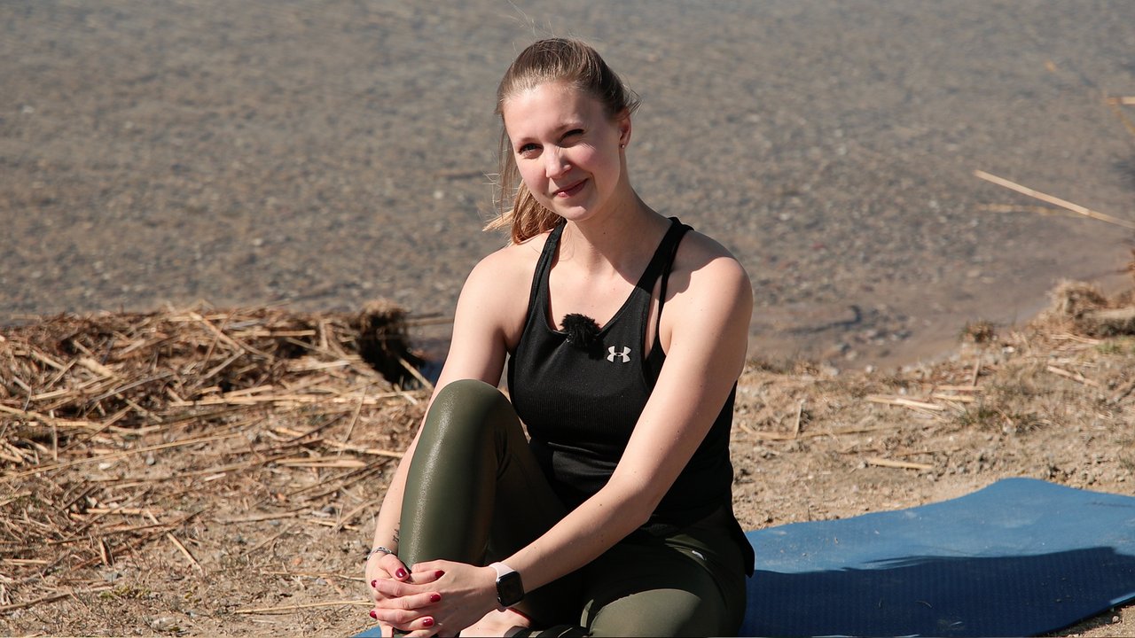 Trainerin Michèle Hertzsch sitzt auf einer Yogamatte