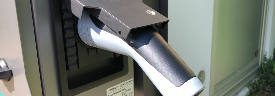 Ein großer Stecker steckt in einer Ladebuchse.