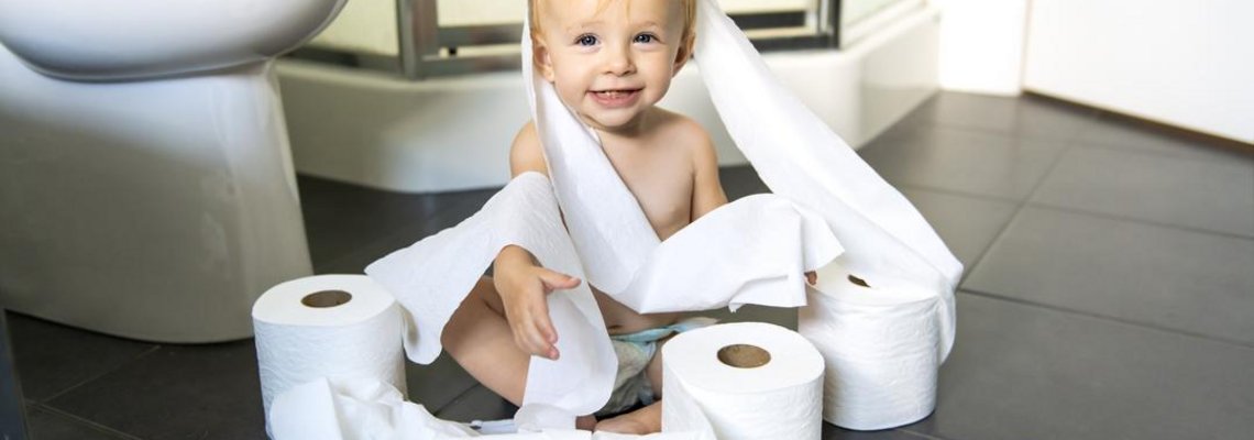 Ein Kleinkind spielt mit Toilettenpapier.