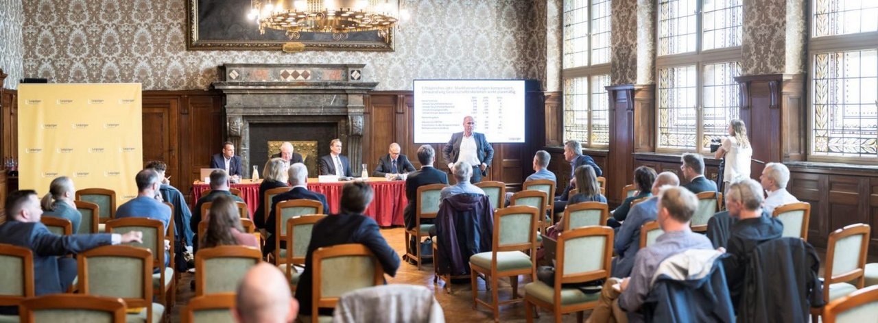 Die Bilanz-PK der Leipziger Gruppe, mit dem Publikum im Vordergrund und im Hintergrund das Podium.