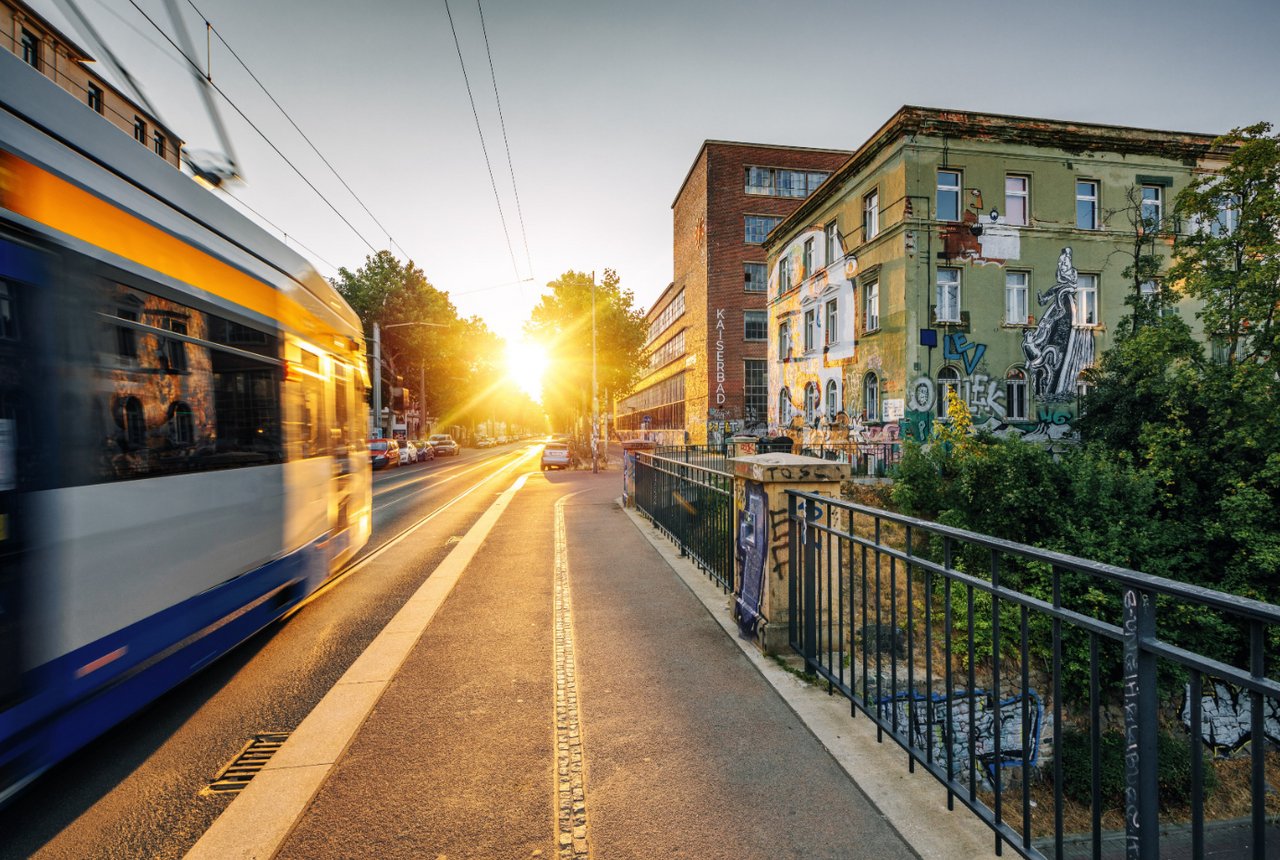 Eine Bahn fährt in Richtung Sonnenuntergang in Plagwitz.