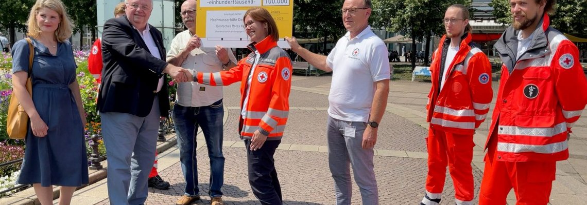 Der Spenden-Scheck wird an das DRK übergeben.