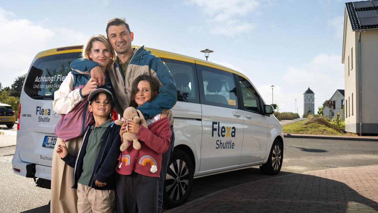 Eine Familie vor einem Flexa-Fahrzeug