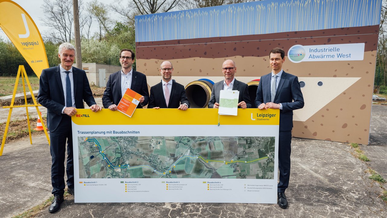 Grünes Licht aus Sachsen und Sachsen-Anhalt für das Leipziger-Stadtwerke-Projekt REFILL: Thomas Pleye, Dr. Maik Piehler, Clemens Schülke, Karsten Rogall und Béla Bélafi (v.l.n.r.) mit einem Schaubild, das den Verlauf der Fernwärmetrasse von Leuna nach Leipzig zeigt. 