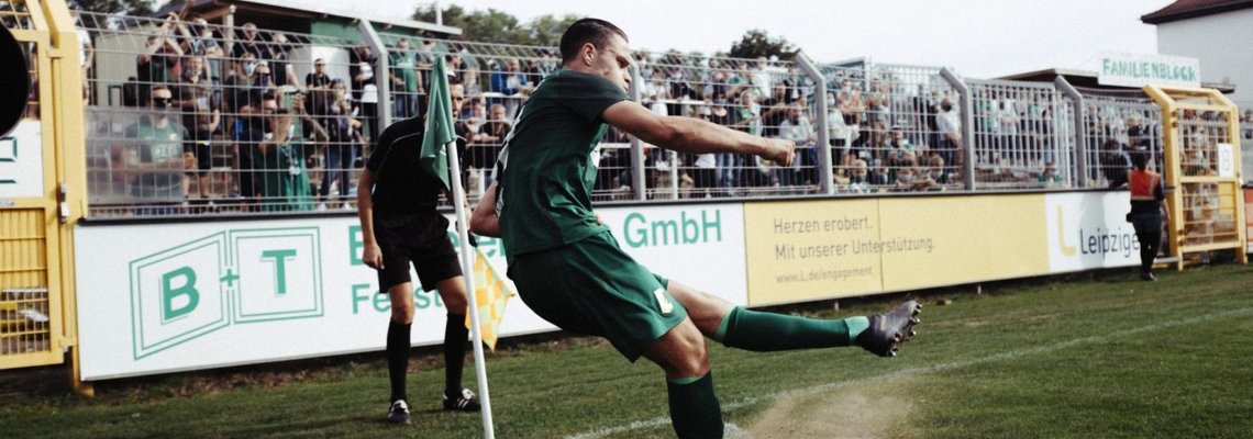 Ein Fußballer schießt aus einer Ecke.