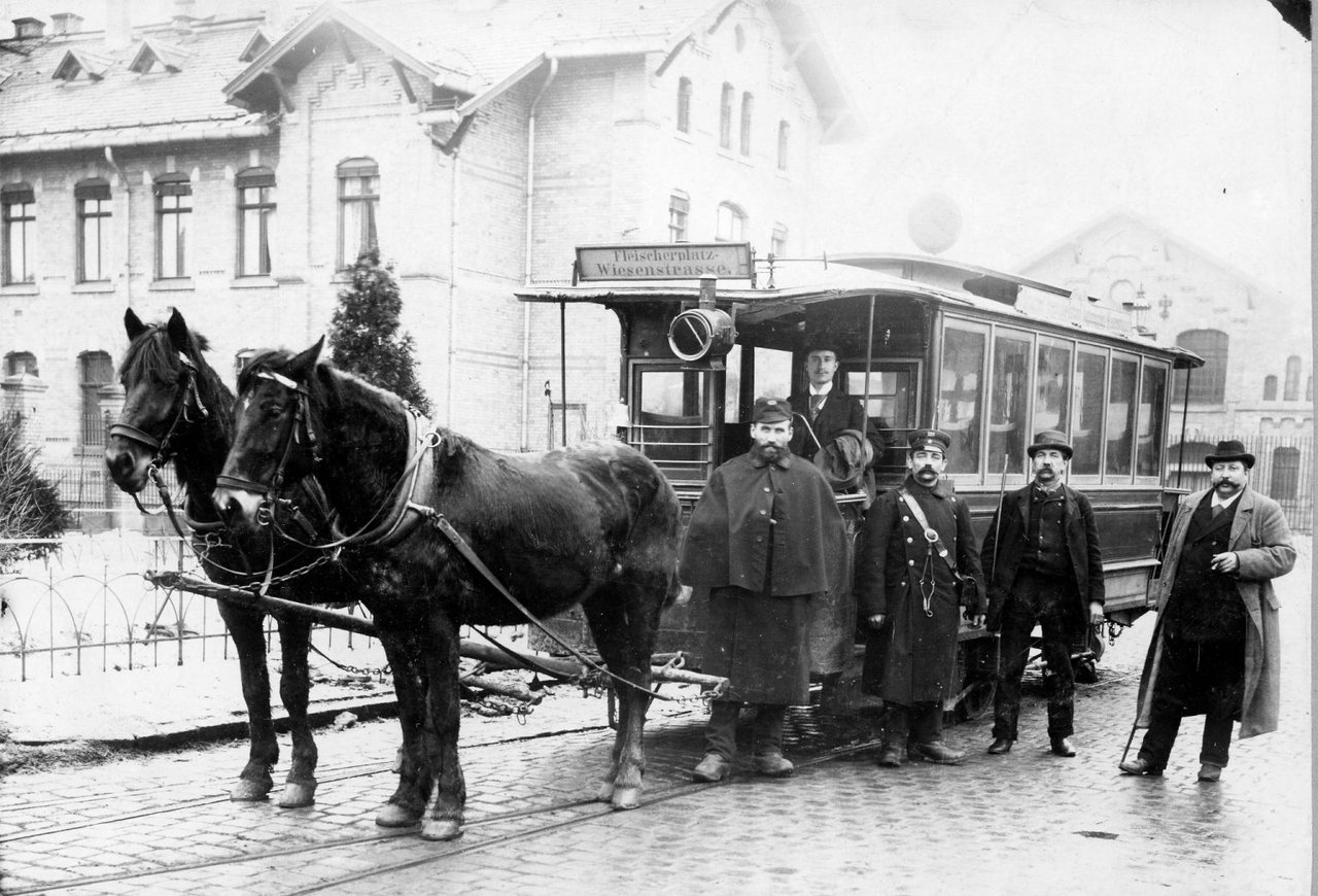 Ein historischer Wagen und davor gespannte Pferden.