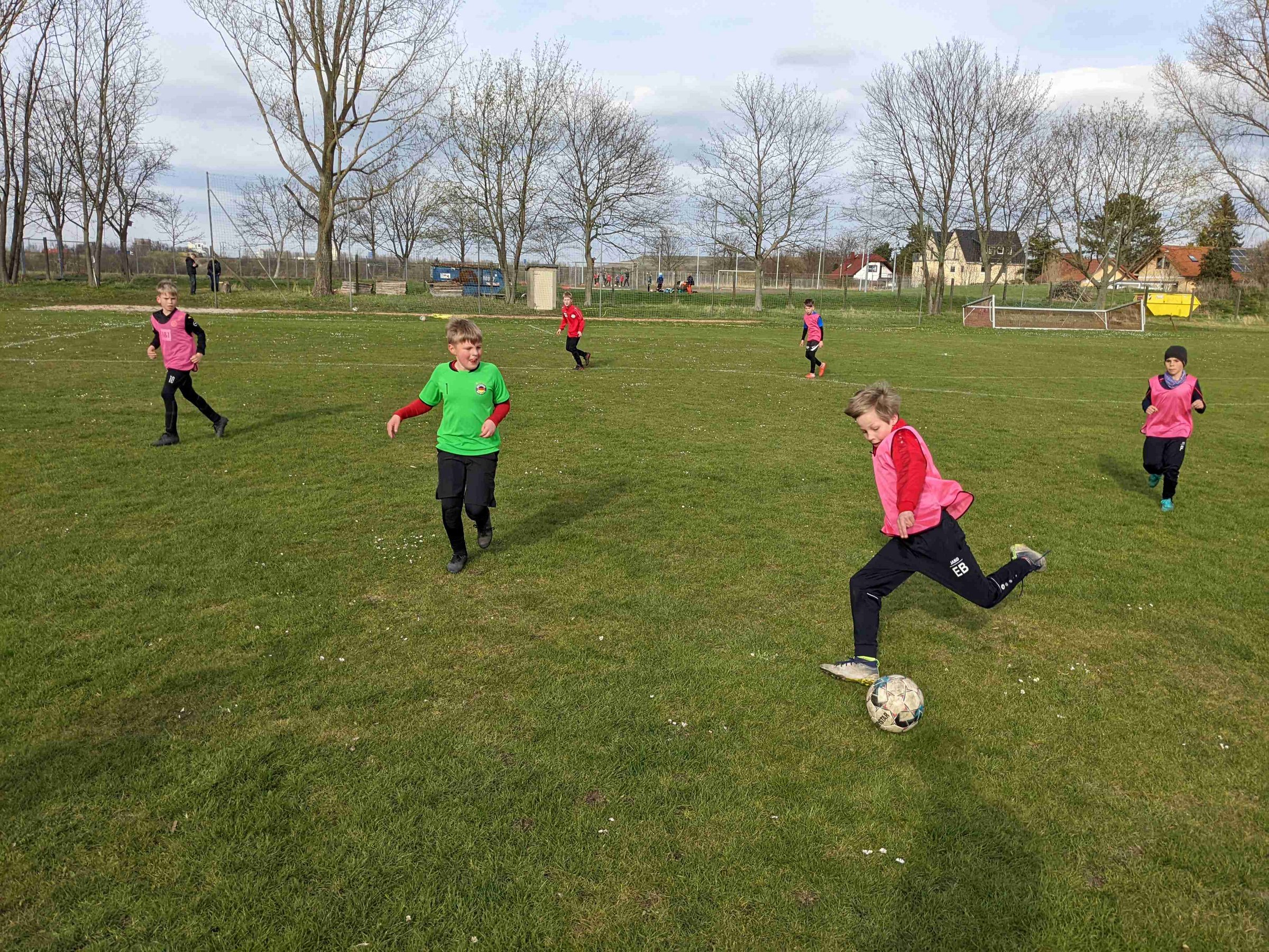 Kinder spielen auf dem Rasen Fußball.