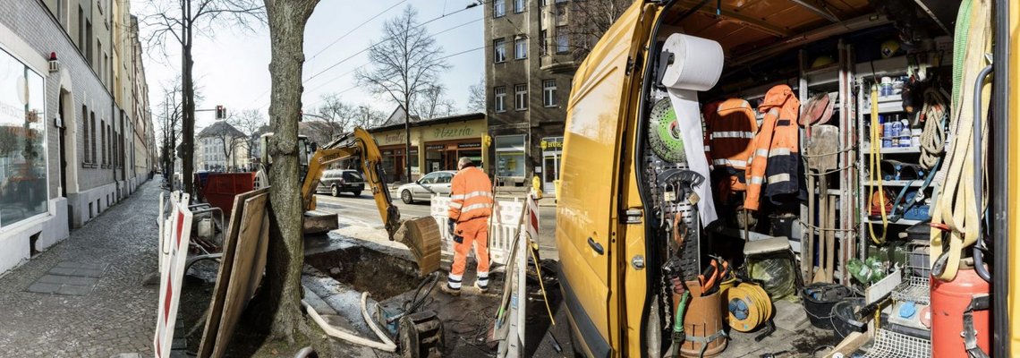 Blick auf ein geöffnetes Baustellenfahrzeug, welches auf einer Baustelle steht. Es ist Werkzeug zu sehen.