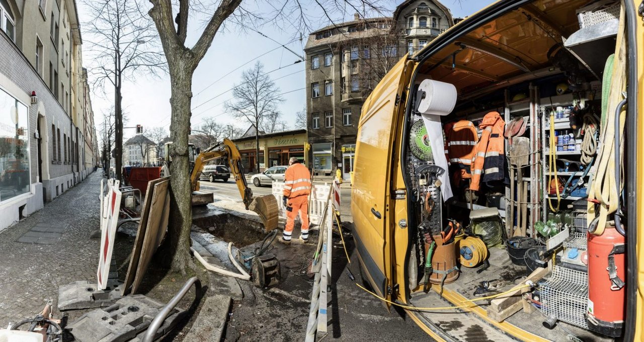 Blick auf ein geöffnetes Baustellenfahrzeug, welches auf einer Baustelle steht. Es ist Werkzeug zu sehen.