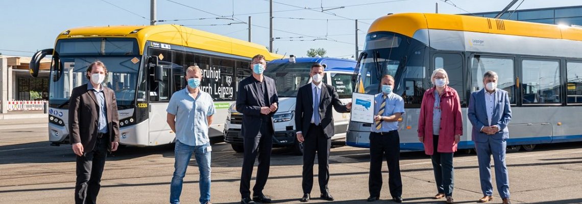 Mehrere Personen stehen vor Fahrzeugen der Leipziger Verkehrsbetrieben.