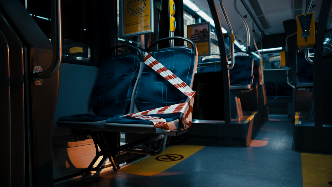 Leerer Sitzplatz in der Straßenbahn. Der Platz ist mit Absperrband umwickelt.
