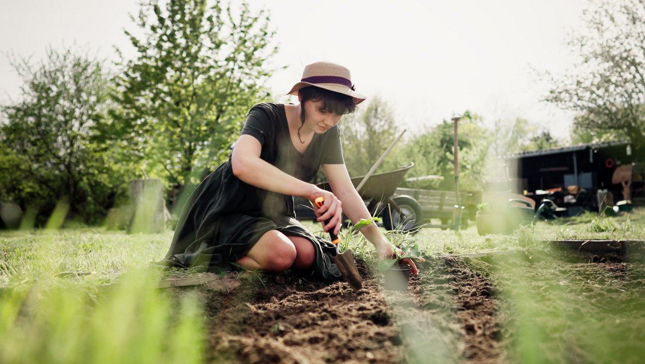 Frau macht Garten frühlingsfit