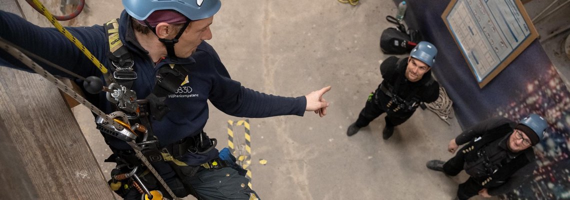 Kletterer blickt auf Kollegen am Boden herab