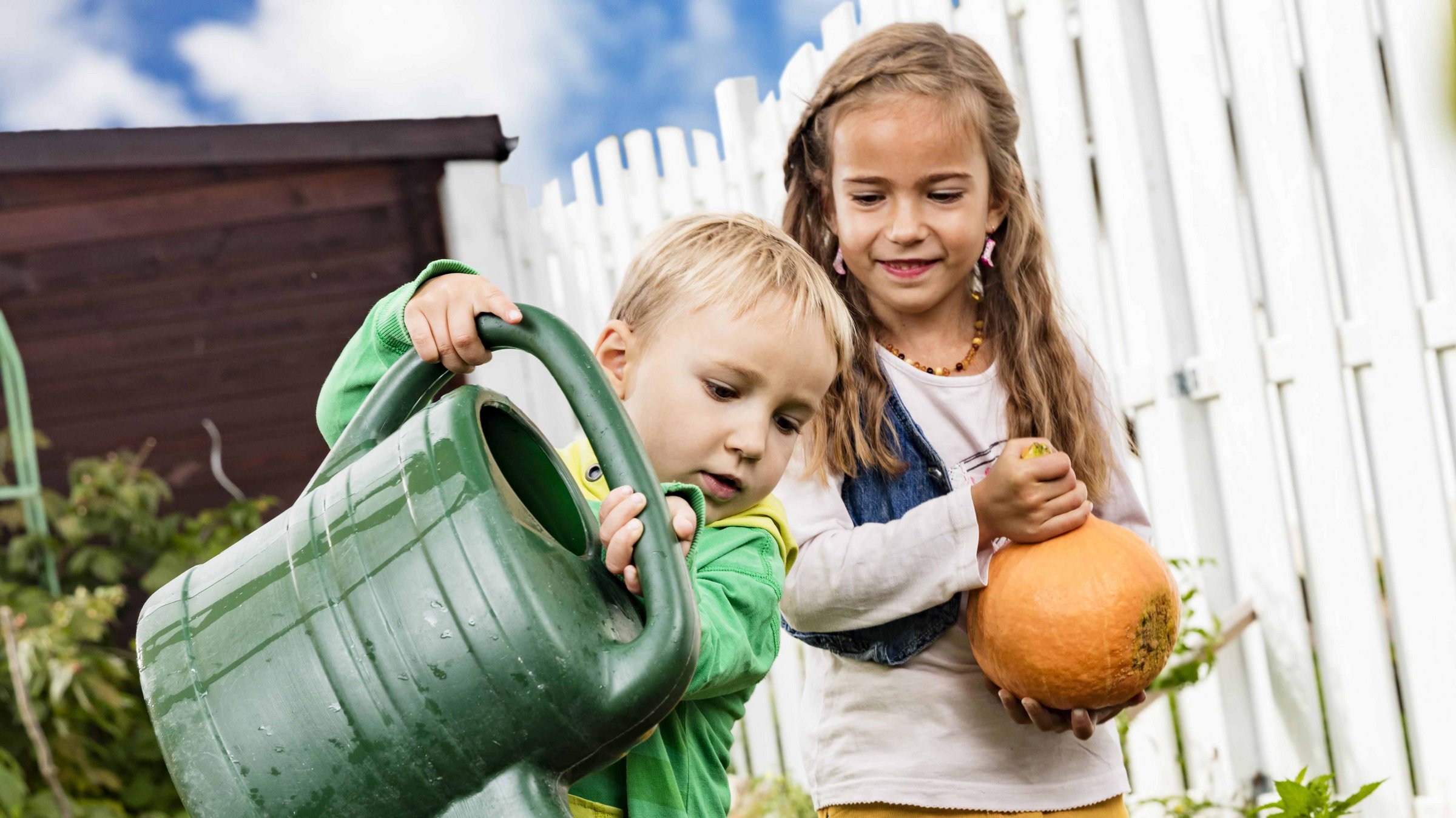 Kinder im Garten mit einer Gießkanne