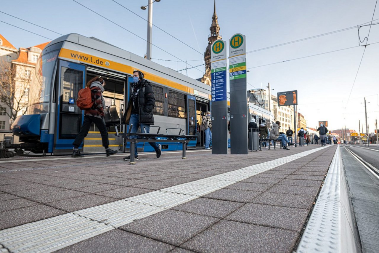 Eine Bahn steht an einer Haltestelle.