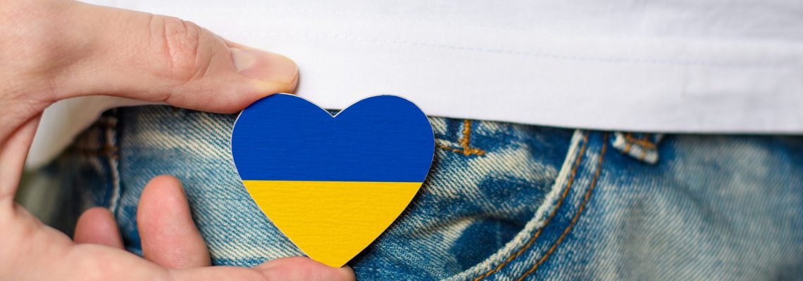 Ein Pin in Herzform mit den Farben blau und gelb.